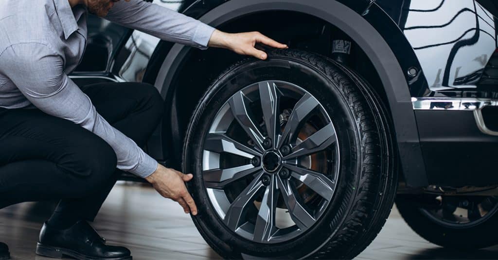 a man checking inexpensive wheels and tires package